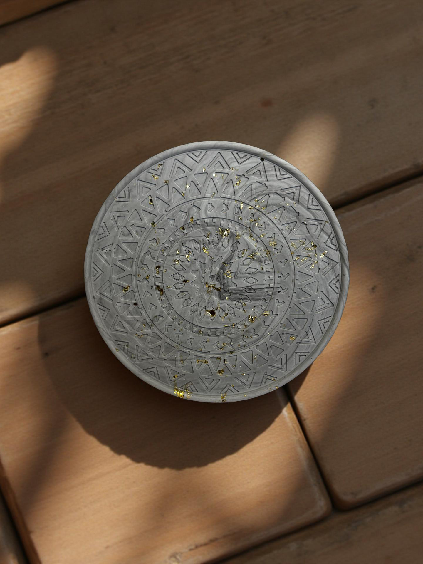 Grey marble coaster on a wooden floor