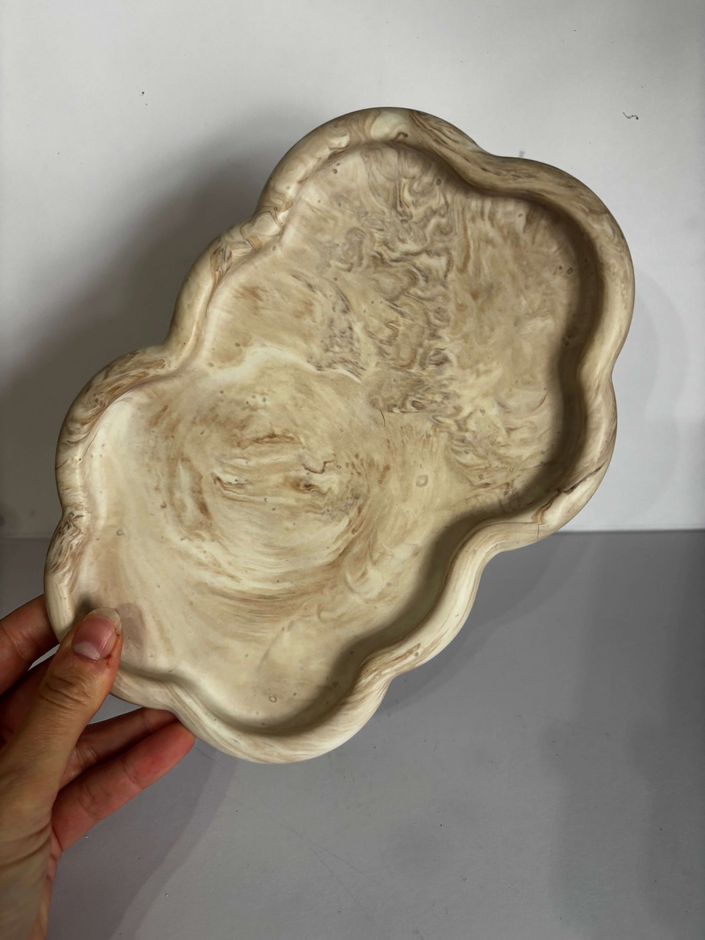 Hand holding a decorative marble tray