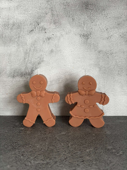 Two gingerbread-shaped cookies on a textured surface