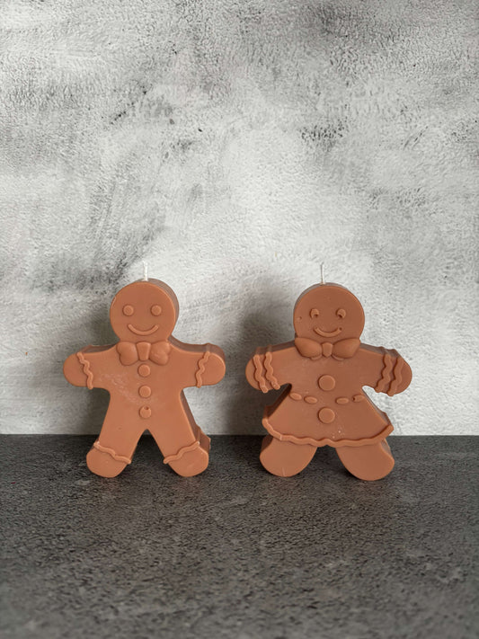 Two gingerbread-shaped cookies on a textured surface
