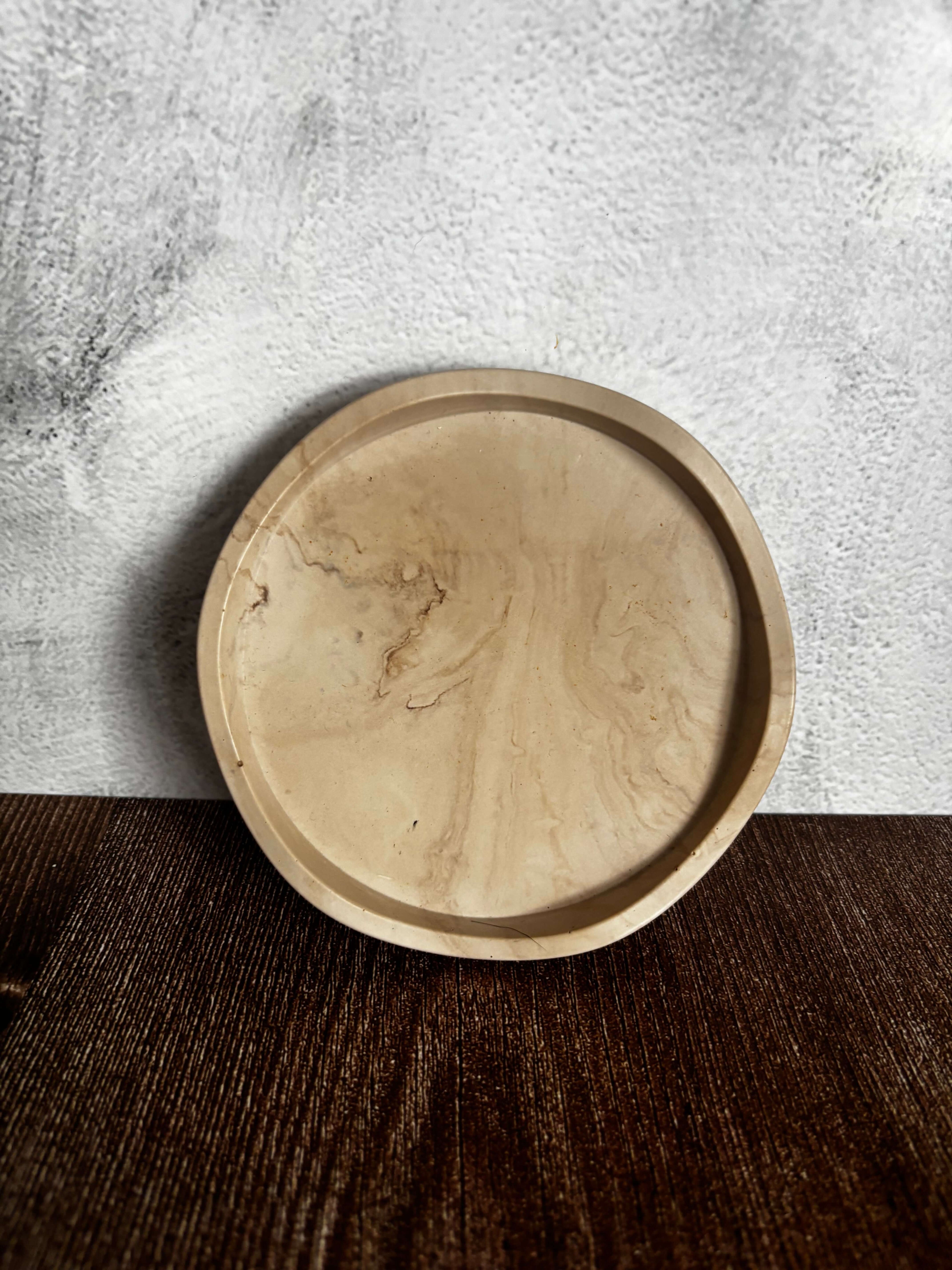 Round beige ceramic dish on a textured surface