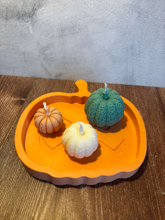 Three small pumpkins on an orange tray