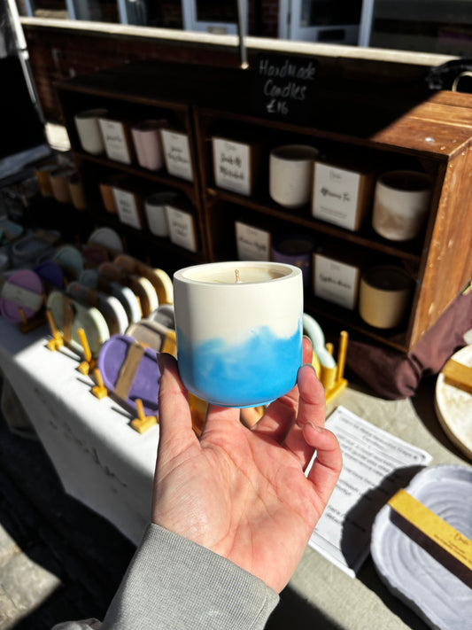 greek summer candle held infront of a market stall 