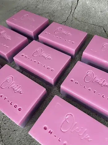 Handmade Pink Lychee & Raspberry glycerine soap bars displayed on a textured surface.